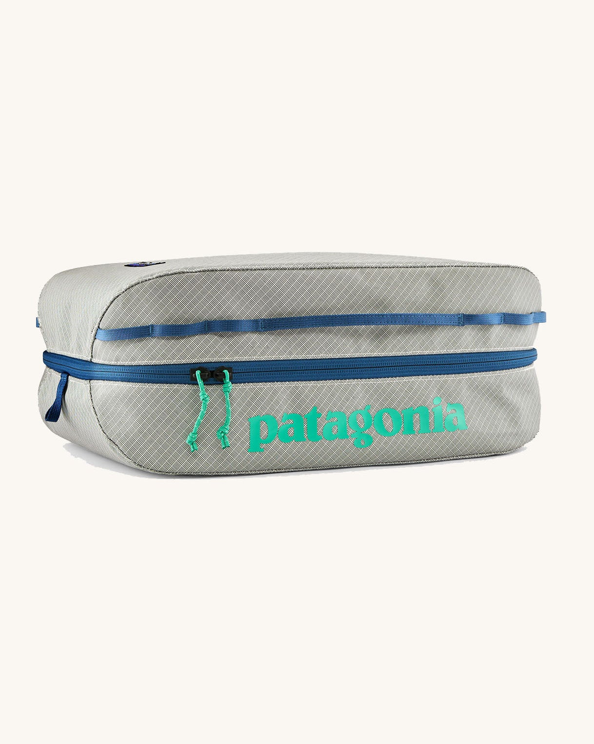 Patagonia black hole 14 litre cube bag in light grey with blue zip and a turquoise brand text logo on front panel