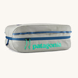 Patagonia black hole 14 litre cube bag in light grey with blue zip and a turquoise brand text logo on front panel