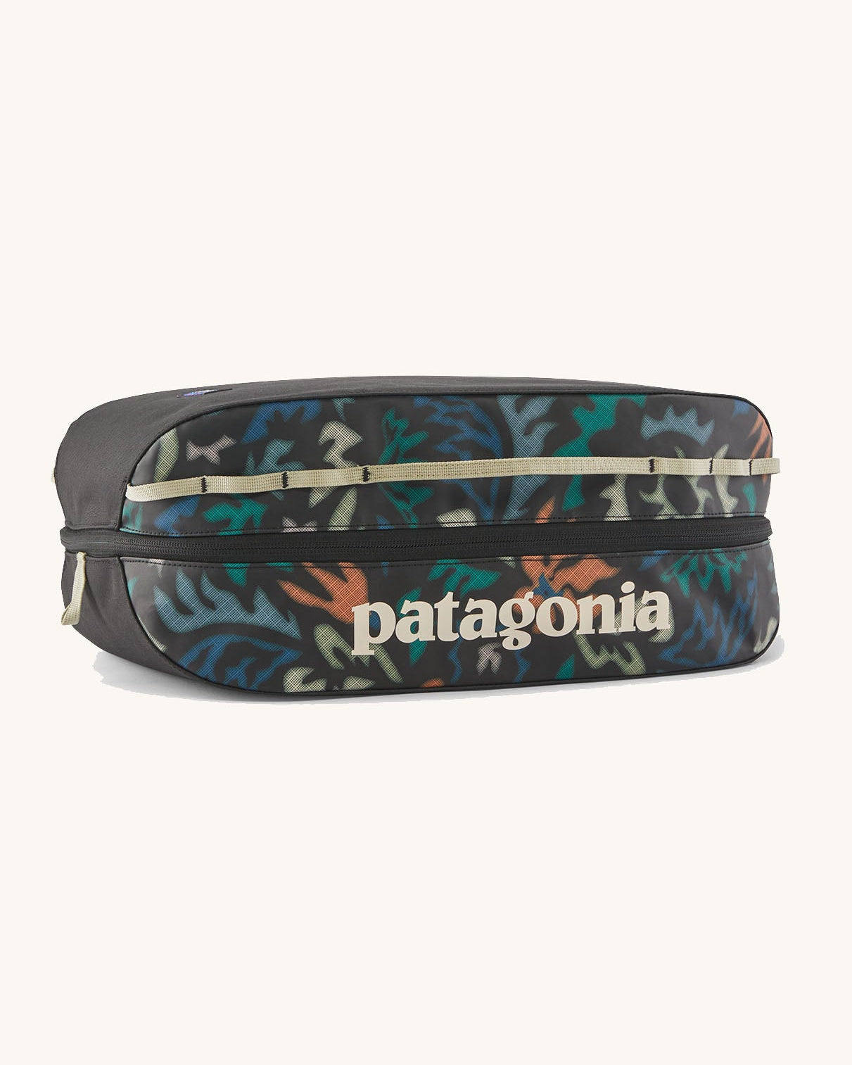 Patagonia black hole 14 litre cube bag in black with abstract pattern design, black zip detail and cream brand text logo on front