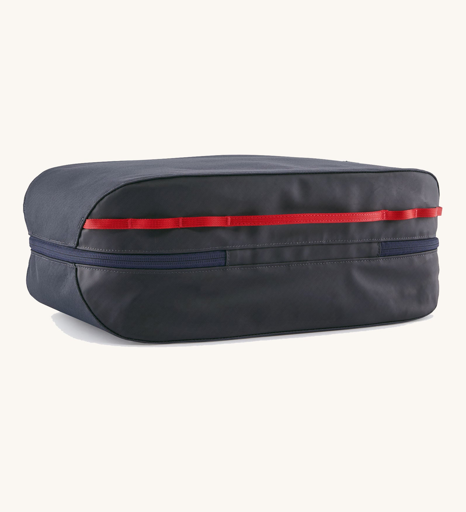 Underside of the Patagonia black hole 14 litre cube bag in dark blue showing zip running underneath and extra red gear loops