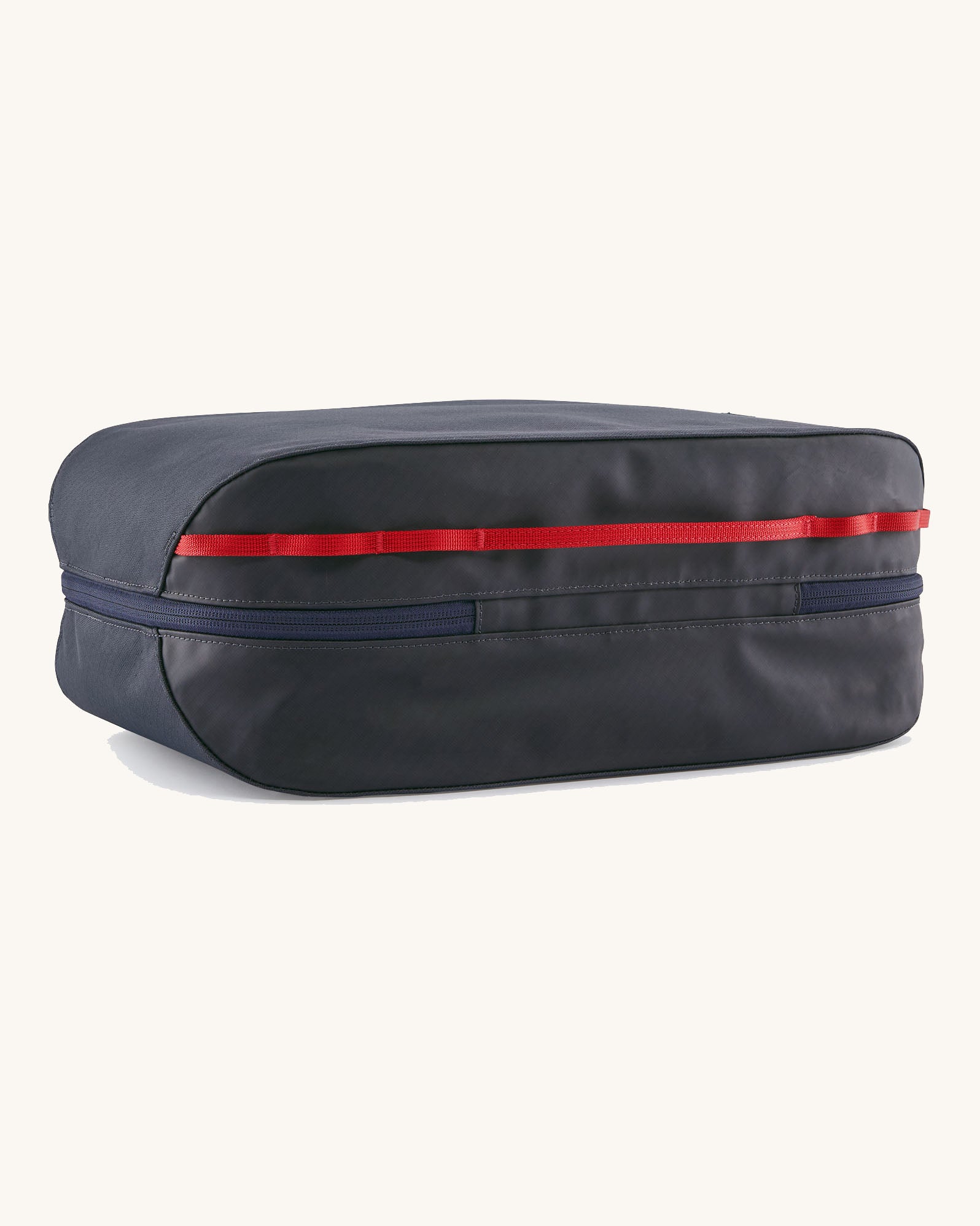 Underside of the Patagonia black hole 14 litre cube bag in dark blue showing zip running underneath and extra red gear loops