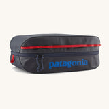 Patagonia black hole 14 litre cube bag in dark blue with matching zip, red gear loops and a blue brand text logo on front panel
