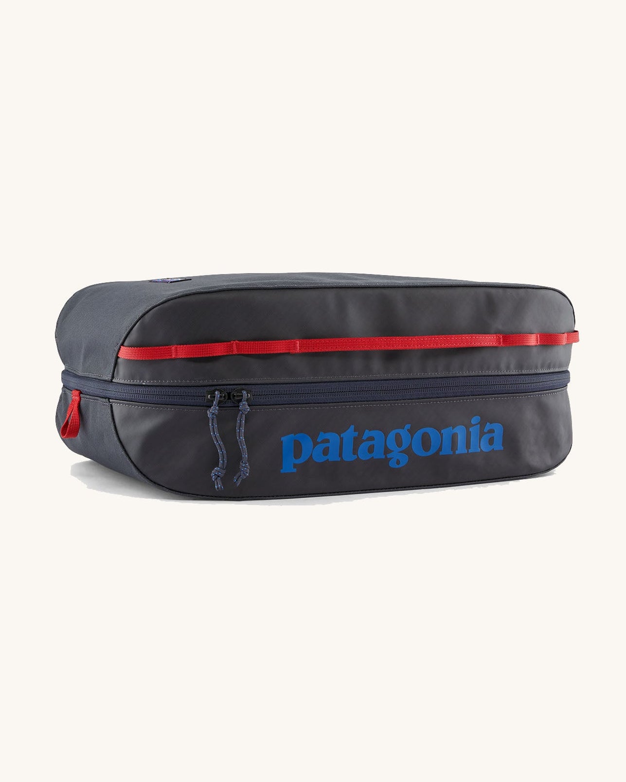 Patagonia black hole 14 litre cube bag in dark blue with matching zip, red gear loops and a blue brand text logo on front panel