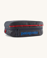 Patagonia black hole 14 litre cube bag in dark blue with matching zip, red gear loops and a blue brand text logo on front panel