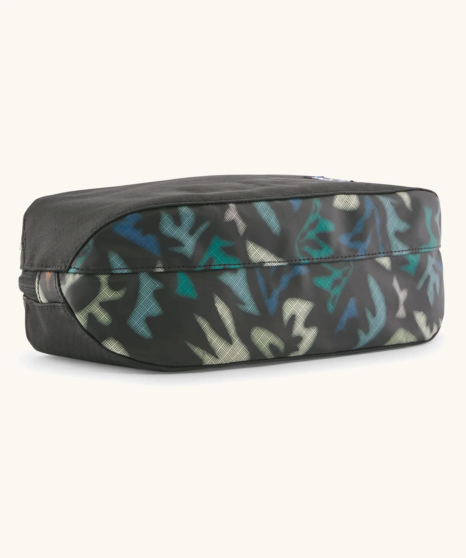 Underside of Patagonia black hole cube 3 litre bag in black with repeating abstract print design