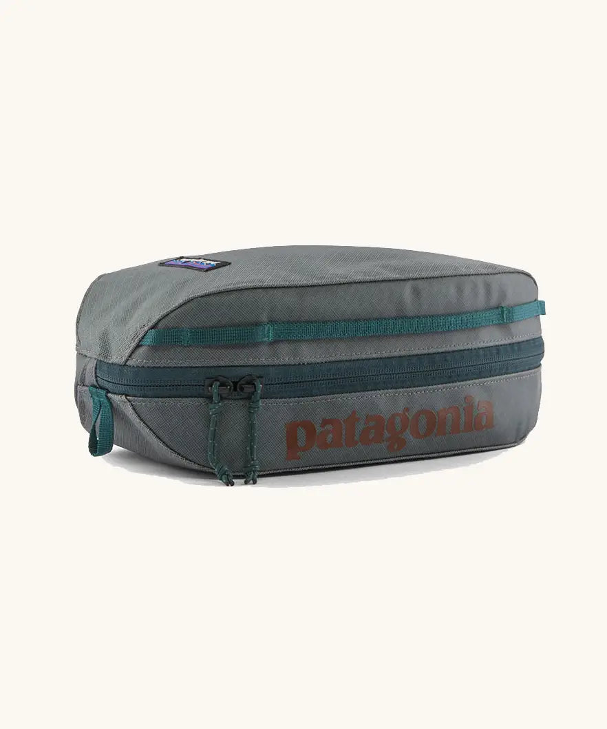 Patagonia black hole cube 3 litre bag in grey with green zip detail and brown brand text on top panel