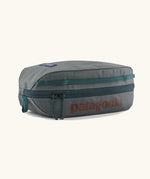 Patagonia black hole cube 3 litre bag in grey with green zip detail and brown brand text on top panel