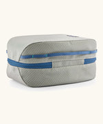 Underside of Patagonia black hole 6 litre cube bag in light grey showing blue zip running underneath