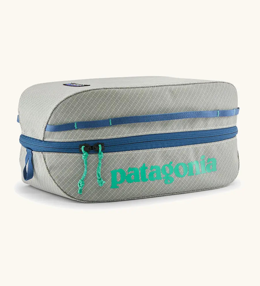 Patagonia black hole 6 litre cube bag in light gret with blue zip detail and turquoise brand text on front panel