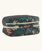 Underside of Patagonia black hole 6 litre cube bag in black with abstract pattern showing cream zip running underneath 