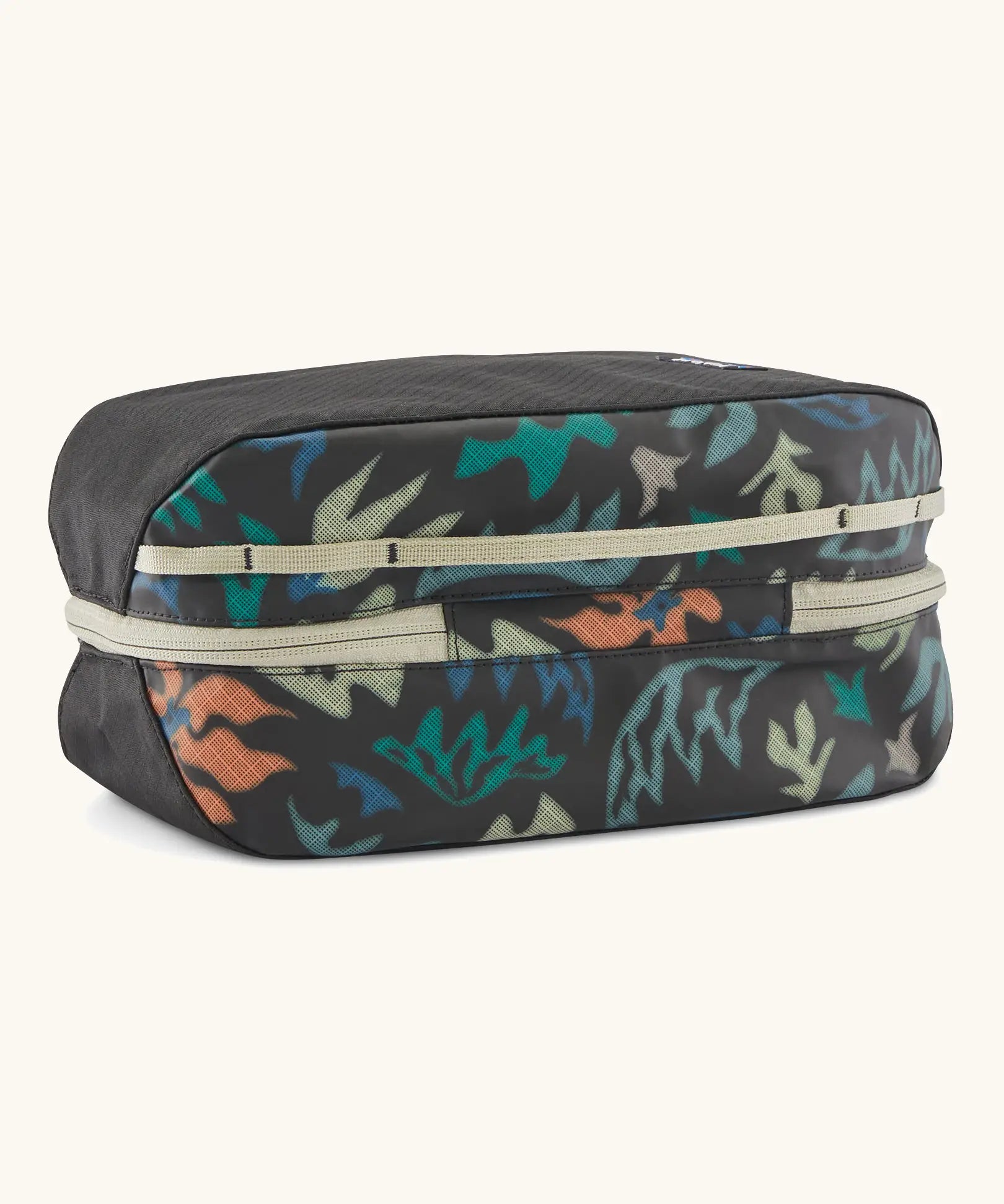 Underside of Patagonia black hole 6 litre cube bag in black with abstract pattern showing cream zip running underneath 