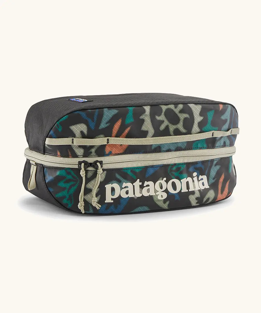 Patagonia black hole 6 litre cube bag in black with abstract pattern design on front panel and cream zip detail