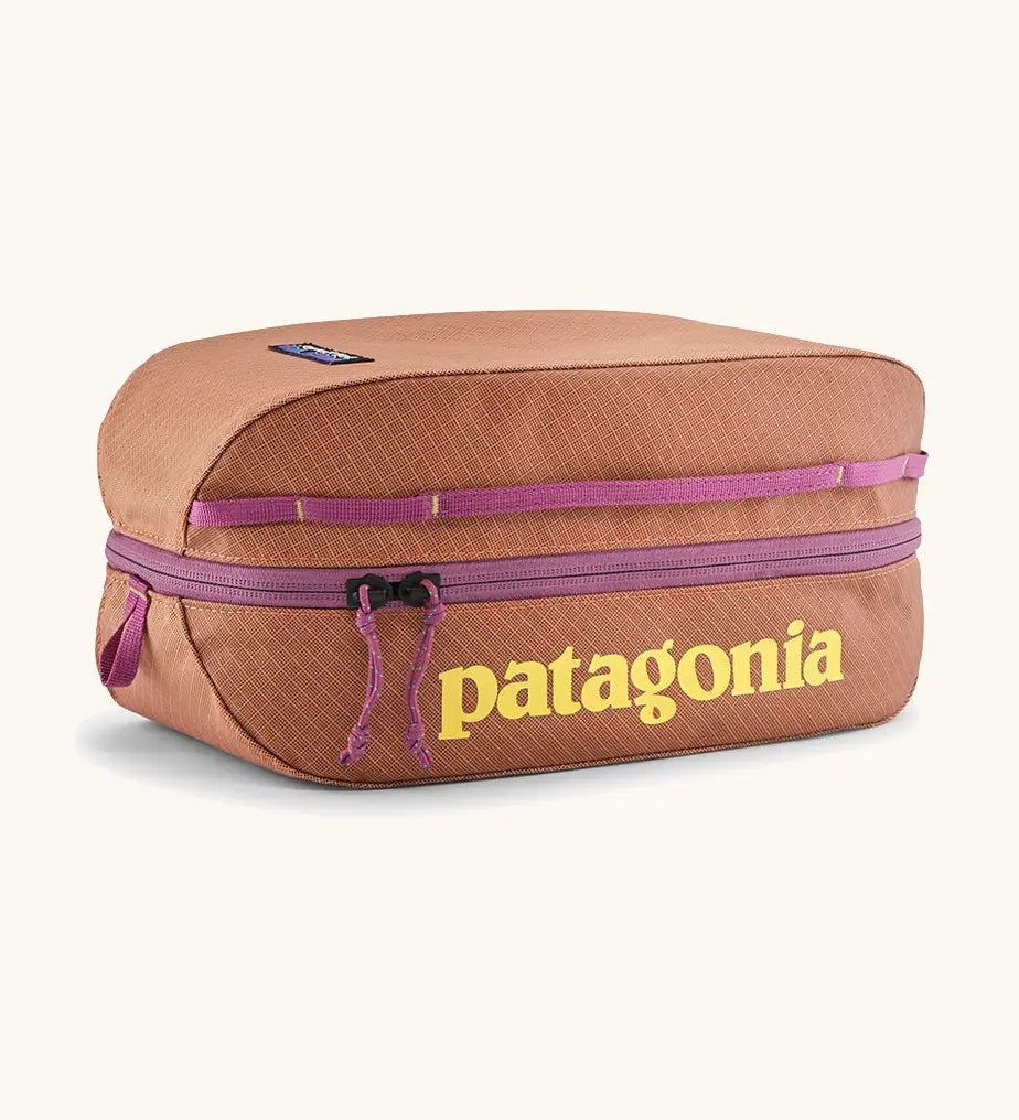 Patagonia black hole 6 litre cube bag in orange with purple zip detail and yellow brand text on front panel