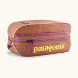 Patagonia black hole 6 litre cube bag in orange with purple zip detail and yellow brand text on front panel