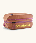 Patagonia black hole 6 litre cube bag in orange with purple zip detail and yellow brand text on front panel