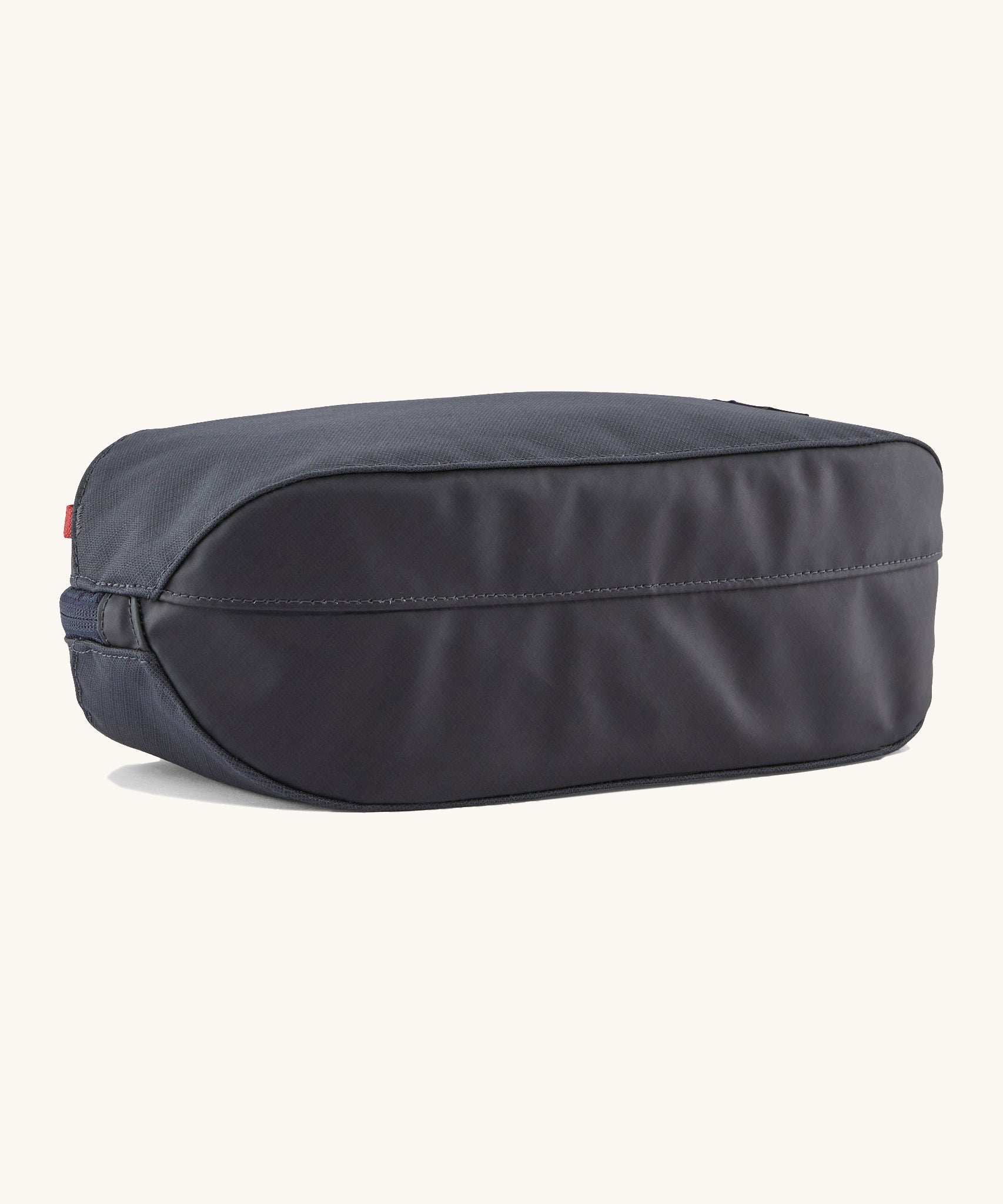 The underside of the Patagonia 3L black hole cube travel bag in smolder blue/ amanita red showing the bottom panel detail