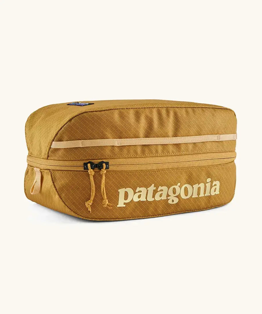Patagonia black hole 6 litre cube bag in mustard yelloqw with matching zip detail and light yellow brand text on front panel