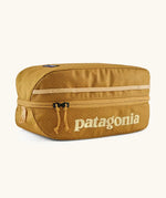 Patagonia black hole 6 litre cube bag in mustard yelloqw with matching zip detail and light yellow brand text on front panel
