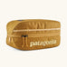 Patagonia black hole 6 litre cube bag in mustard yelloqw with matching zip detail and light yellow brand text on front panel
