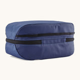 The back of the Patagonia black hole 6 litre cube bag in current blue. showing the main zip compartment running around the bag