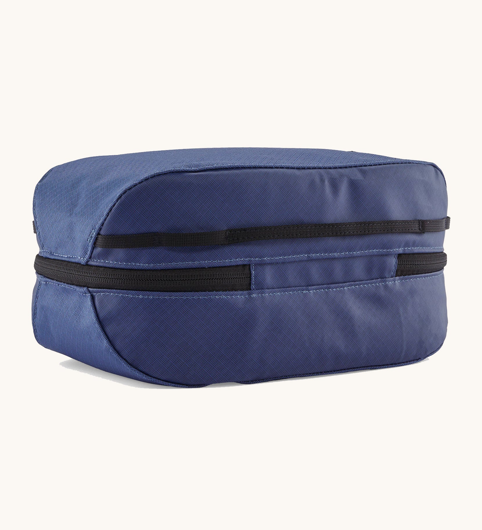 The back of the Patagonia black hole 6 litre cube bag in current blue. showing the main zip compartment running around the bag