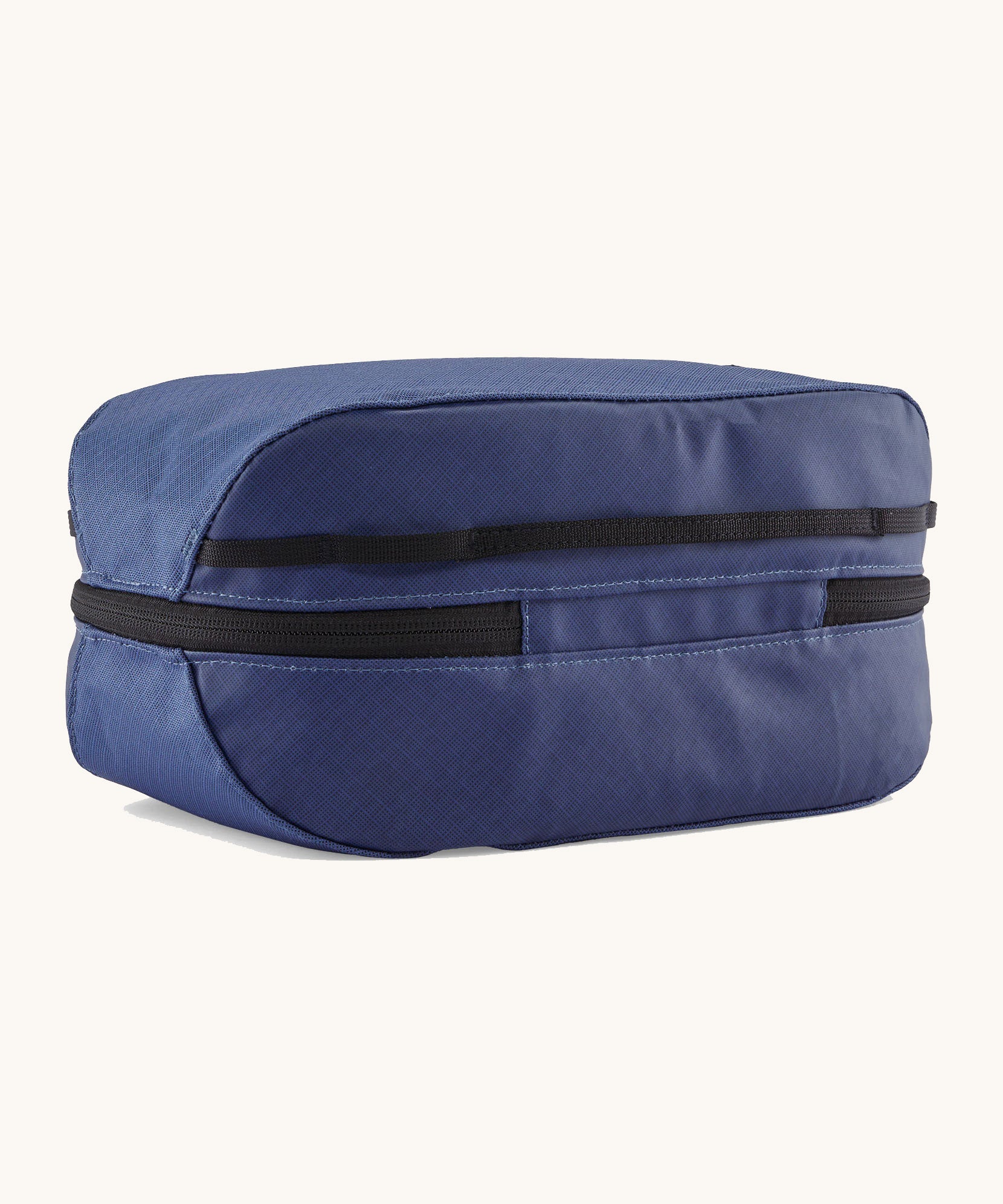 The back of the Patagonia black hole 6 litre cube bag in current blue. showing the main zip compartment running around the bag