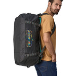 A person carrying the Patagonia Black Hole Duffel 70L Ink Black on their back with the shoulder straps