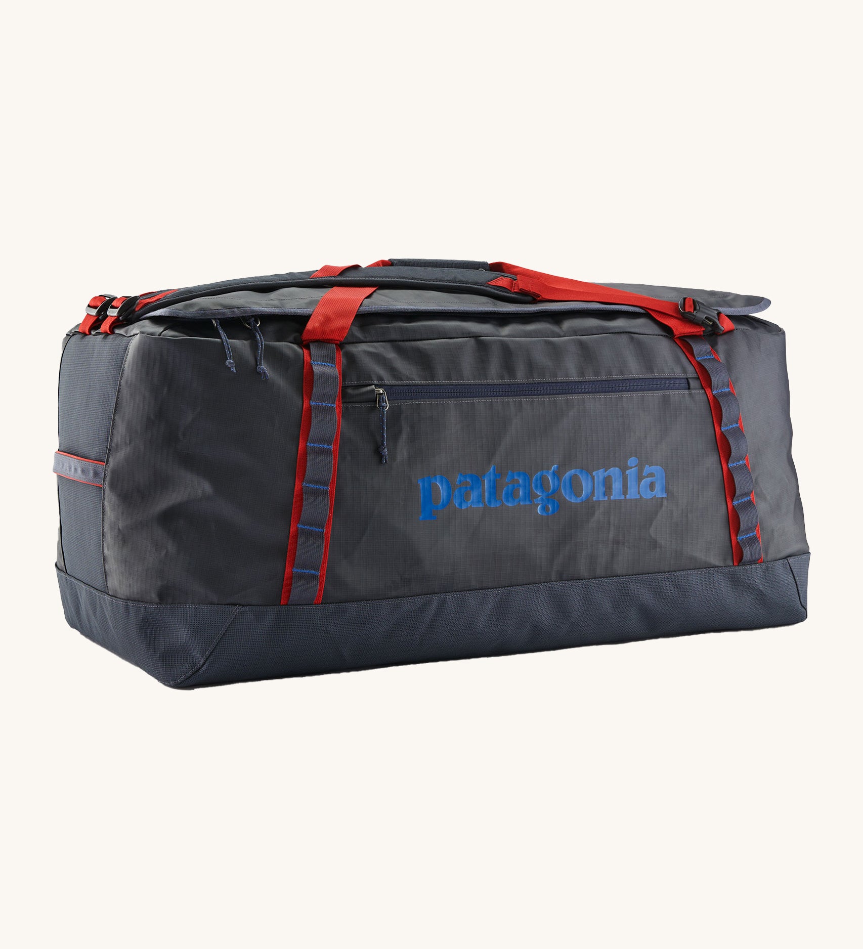 Patagonia black hole 100L duffel bag in smolder blue / amanita red available at Babipur. A dark blue bag with red trim and blue branding on the side. Features shoulders straps and a handle on the top for easy carrying.