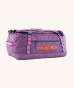 Patagonia black hole 40l duffel bag in brisk purple available at Babipur. A bright purple bag with orange branding on the side. Features shoulders straps and a handle on the top for easy carrying.