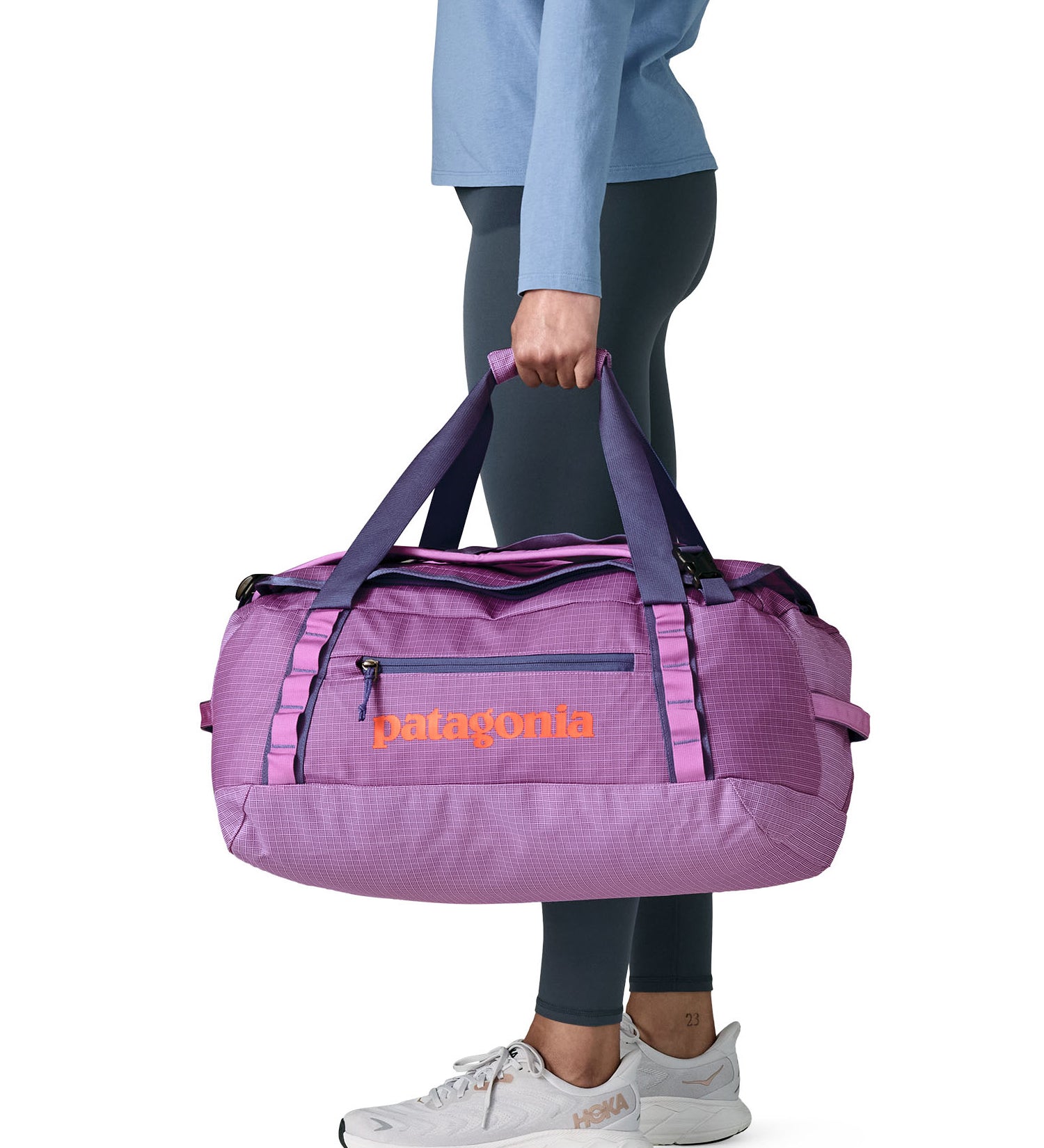 A woman carrying the Patagonia black hole 40l duffel bag in brisk purple available at Babipur. 