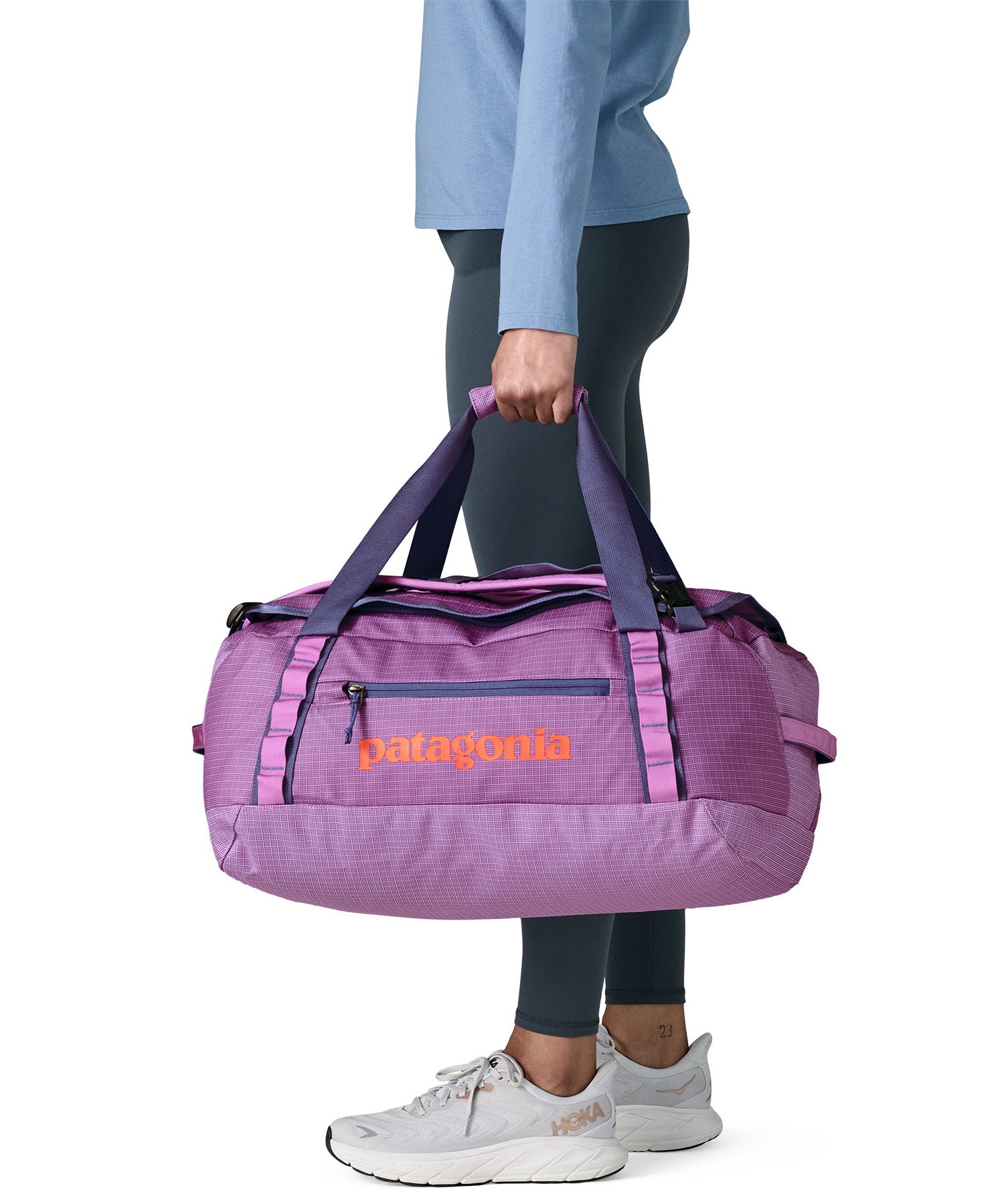 A woman carrying the Patagonia black hole 40l duffel bag in brisk purple available at Babipur. 