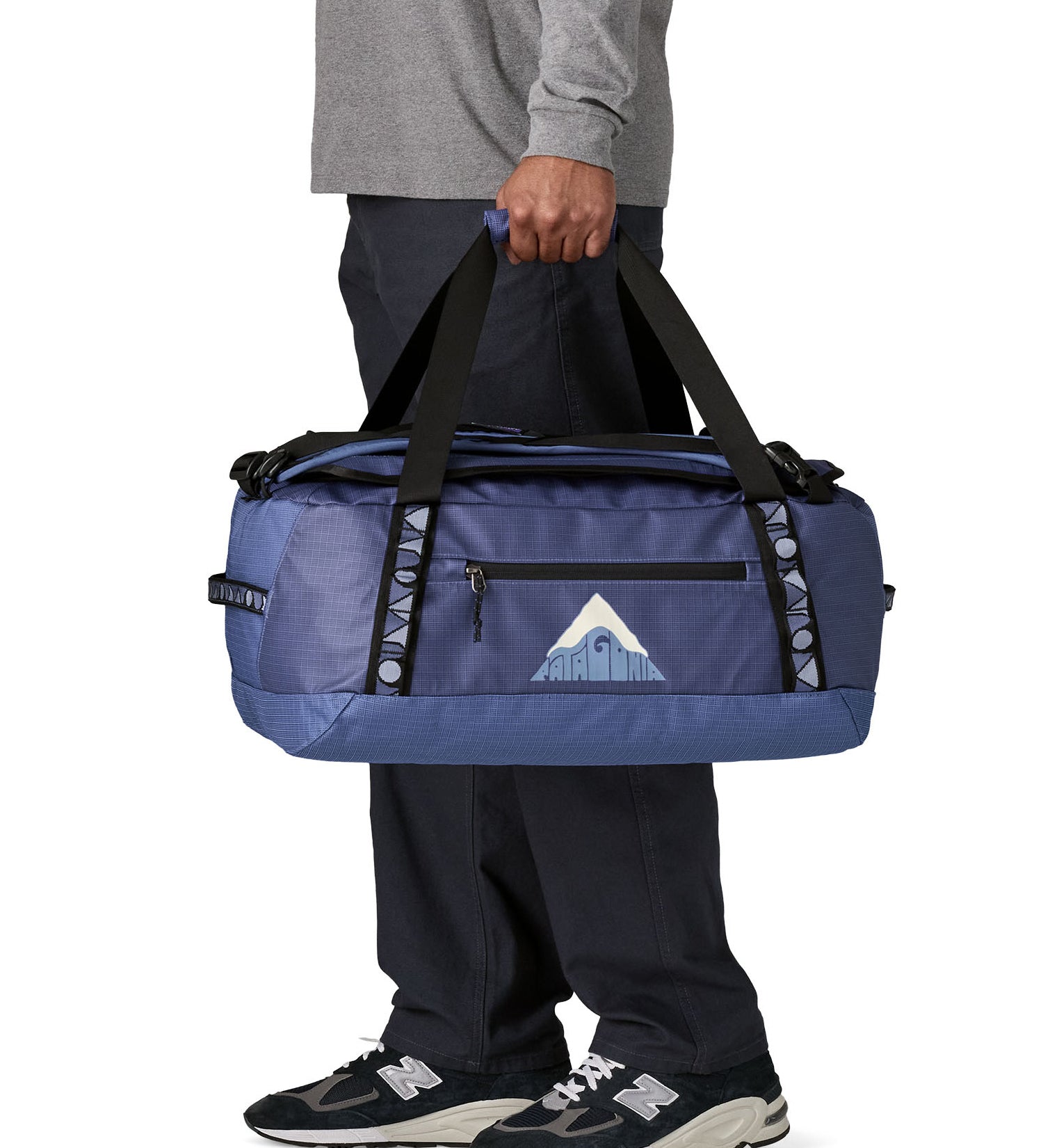 A man carrying the Patagonia black hole 40l duffel bag in current blue available at Babipur. 