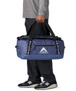 A man carrying the Patagonia black hole 40l duffel bag in current blue available at Babipur. 