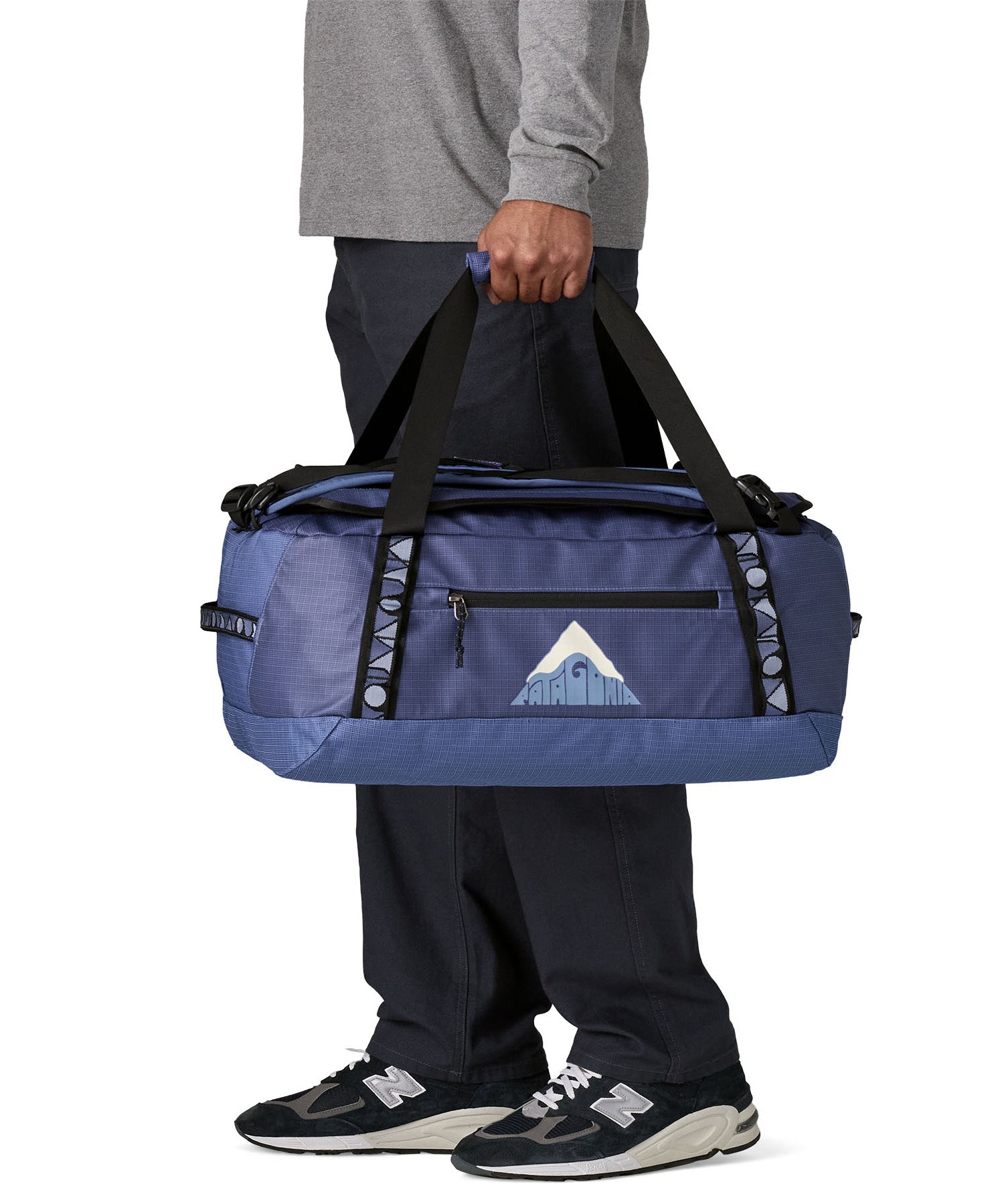 A man carrying the Patagonia black hole 40l duffel bag in current blue available at Babipur. 