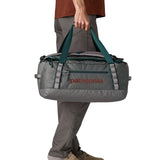 A man carrying the Patagonia black hole 40l duffel bag in noble grey available at Babipur. 