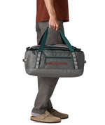 A man carrying the Patagonia black hole 40l duffel bag in noble grey available at Babipur. 