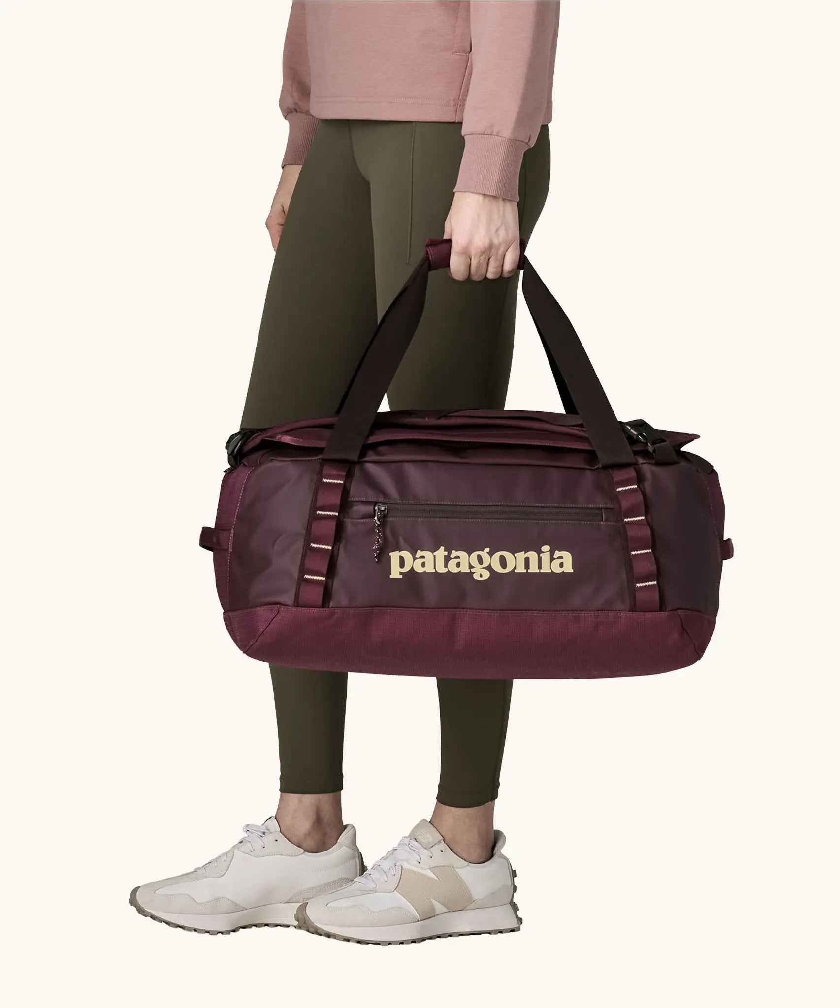 Patagonia Black Hole Duffel 40L in Berry Fig. Bag being held by handle straps. 