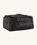 Patagonia black hole 55L duffel bag in black on black available at Babipur. An all black backpack with  shoulders straps and a handle on the top for easy carrying.