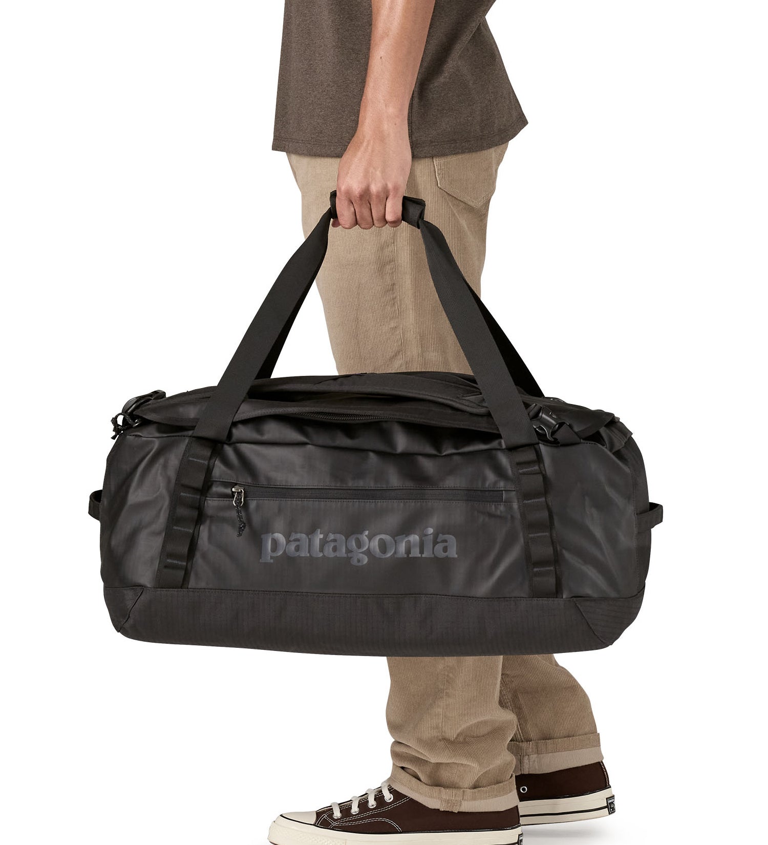 A man carrying the Patagonia black hole 55L duffel bag in black on black available at Babipur. 