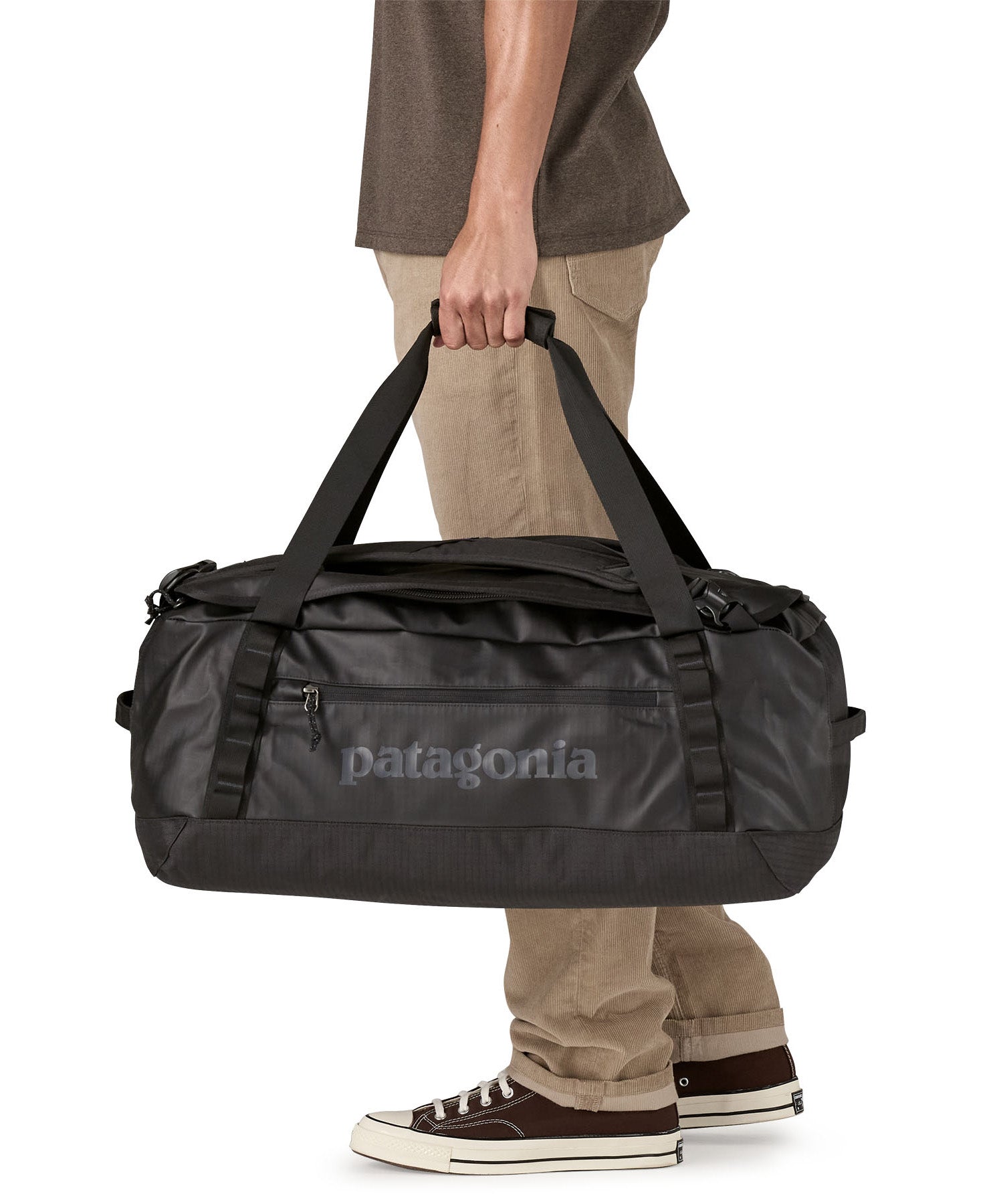A man carrying the Patagonia black hole 55L duffel bag in black on black available at Babipur. 