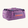 Patagonia black hole 55L duffel bag in brisk purple available at Babipur. A bright purple bag with orange branding on the side. Features shoulders straps and a handle on the top for easy carrying.