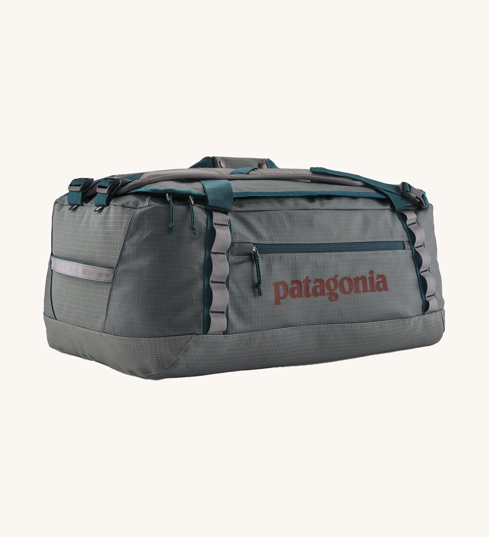 Patagonia black hole 55L duffel bag in noble grey available at Babipur. A dark grey bag with green trim and brown branding on the side. Features shoulders straps and a handle on the top for easy carrying.