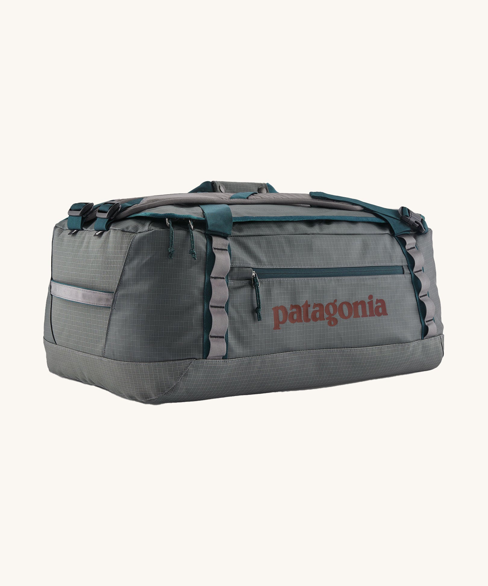 Patagonia black hole 55L duffel bag in noble grey available at Babipur. A dark grey bag with green trim and brown branding on the side. Features shoulders straps and a handle on the top for easy carrying.