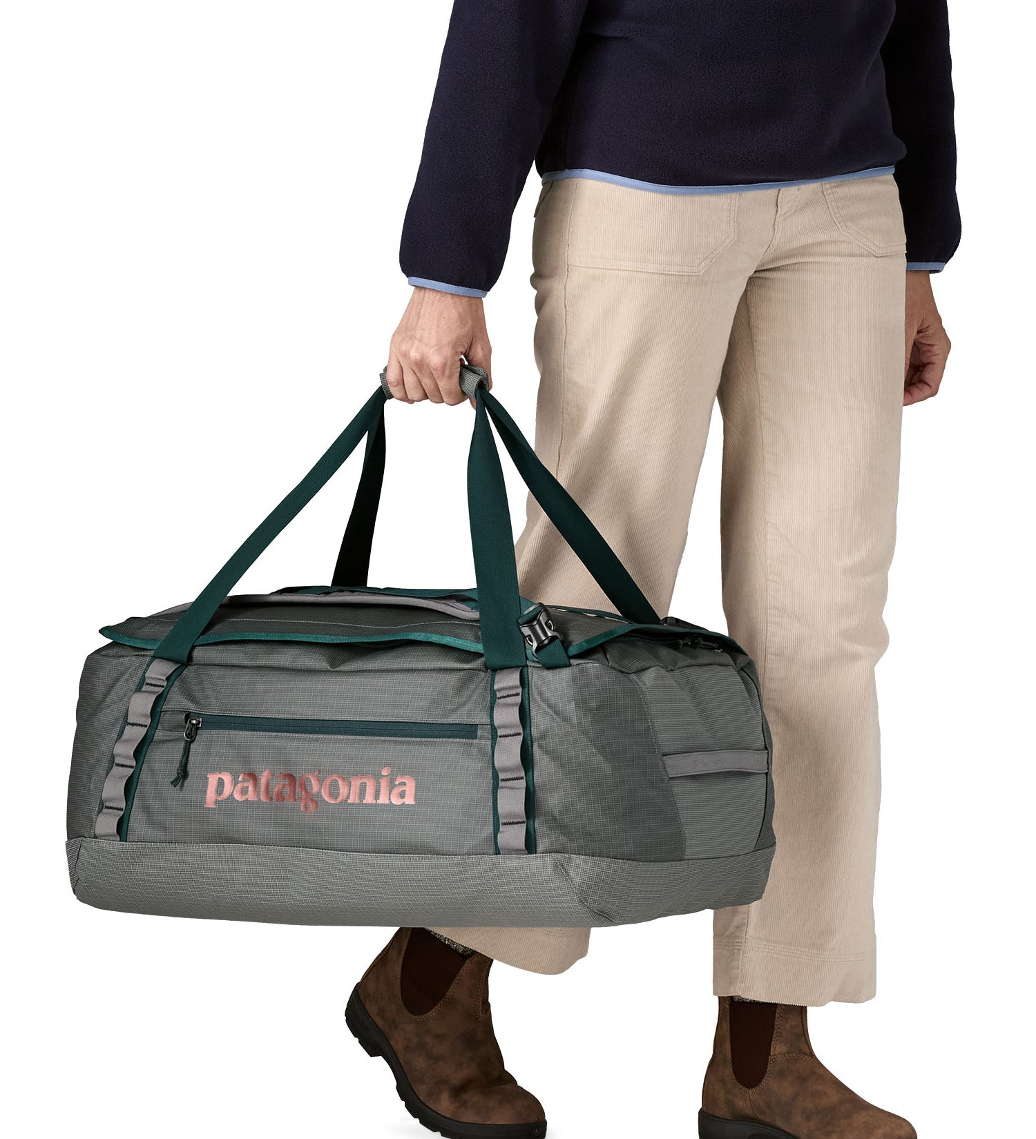 A woman carrying the Patagonia black hole 55L duffel bag in noble grey available at Babipur. 