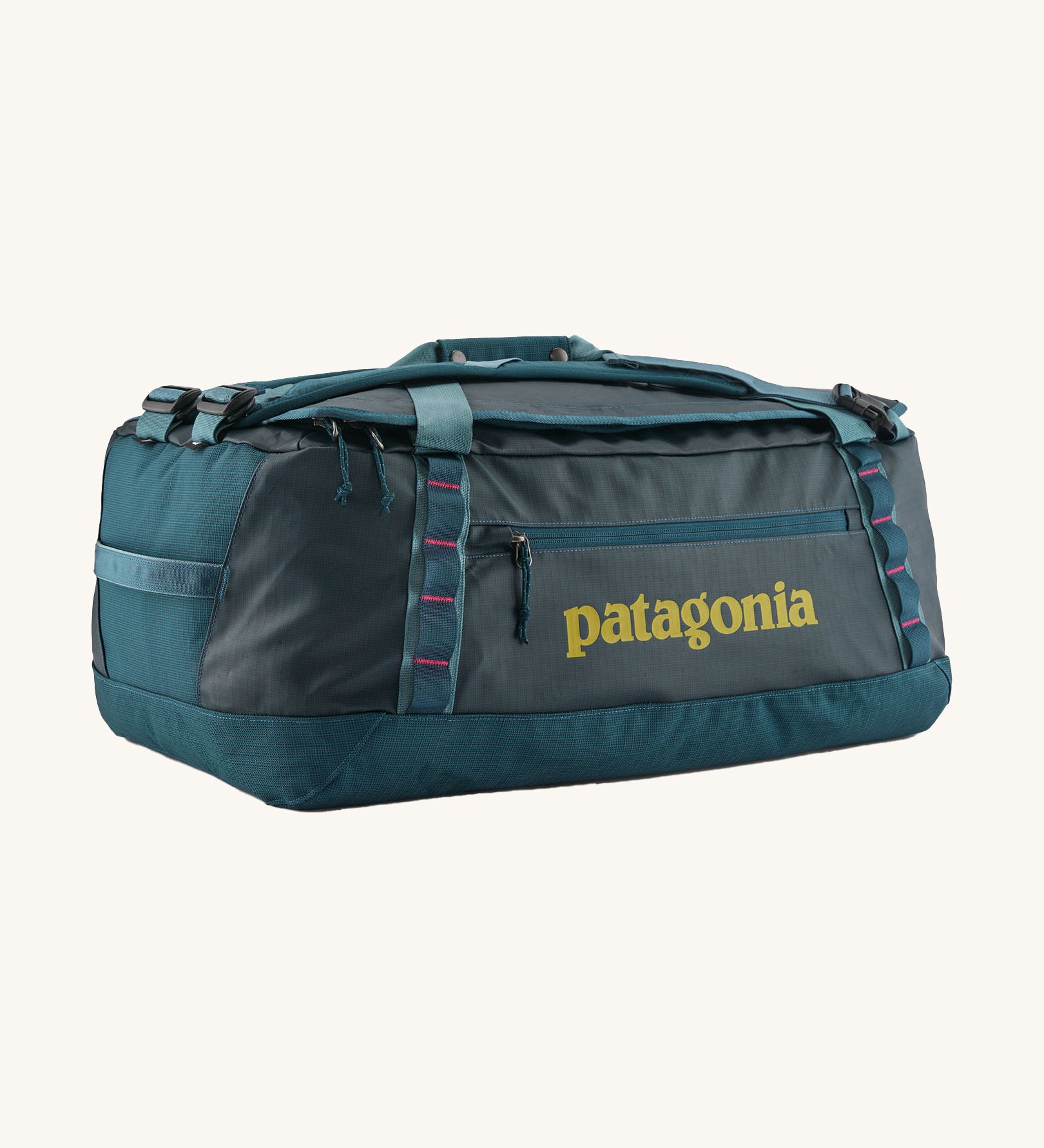 Patagonia black hole 55L duffel bag in tidal teal / luminous pink available at Babipur. A dark teal colour bag with pink trim and a mustard colour branding  on the side. Features shoulders straps and a handle on the top for easy carrying.