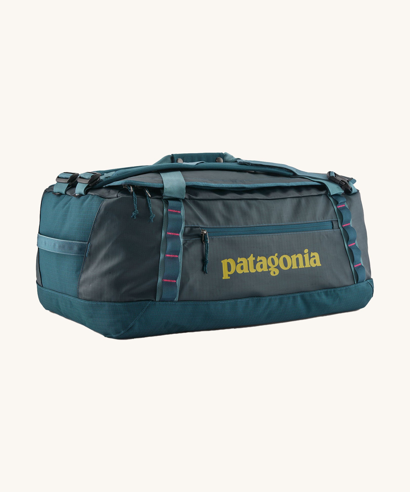 Patagonia black hole 55L duffel bag in tidal teal / luminous pink available at Babipur. A dark teal colour bag with pink trim and a mustard colour branding  on the side. Features shoulders straps and a handle on the top for easy carrying.