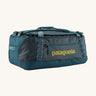 Patagonia black hole 55L duffel bag in tidal teal / luminous pink available at Babipur. A dark teal colour bag with pink trim and a mustard colour branding  on the side. Features shoulders straps and a handle on the top for easy carrying.