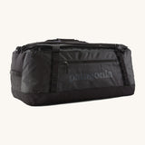 Patagonia black hole 70L duffel bag in black on black available at Babipur. An all black backpack with  shoulders straps and a handle on the top for easy carrying.