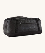 Patagonia black hole 70L duffel bag in black on black available at Babipur. An all black backpack with  shoulders straps and a handle on the top for easy carrying.