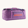 Patagonia black hole 70L duffel bag in brisk purple available at Babipur. A bright purple bag with orange branding on the side. Features shoulders straps and a handle on the top for easy carrying.